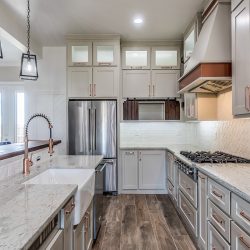 A clean kitchen with off-white colored cabinets, How Wide Should Aisles Be In A Galley Kitchen?