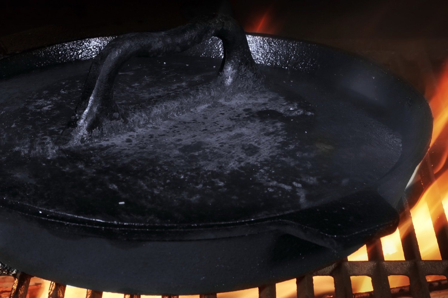 Frying Pan With Heavy Lid. Grill Pan On Hot Flaming BBQ Grate. Cast Iron Grill Pan With Gridiron, Closeup View.