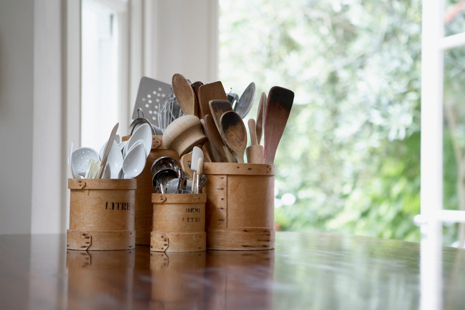 Kitchen utensils in containers on table