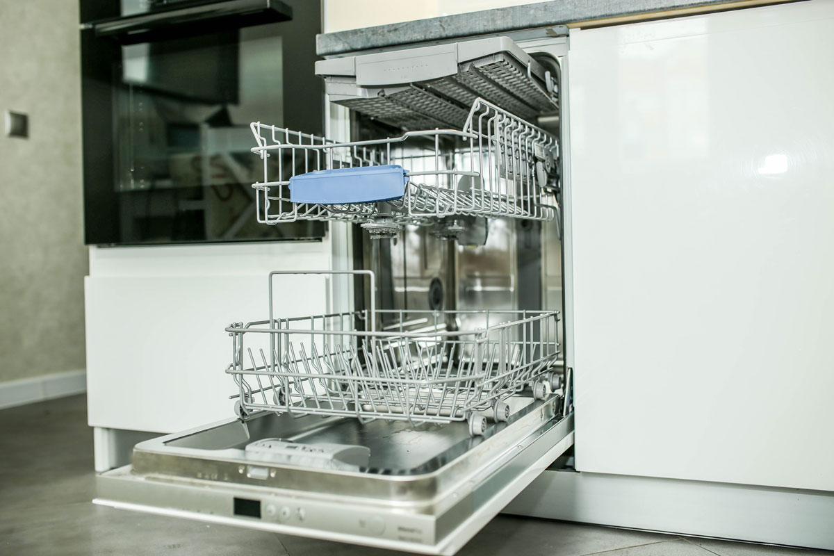 Modern electric dishwasher built into the furniture in the kitchen