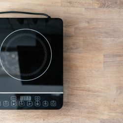 Modern kitchen appliance on wooden table, Can I Use Non Stick Pans On An Induction Stove? [Yes! How To & Tips]