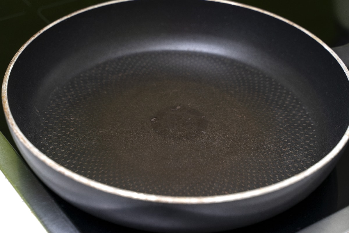 Old empty non-stick frying pan with damaged coating