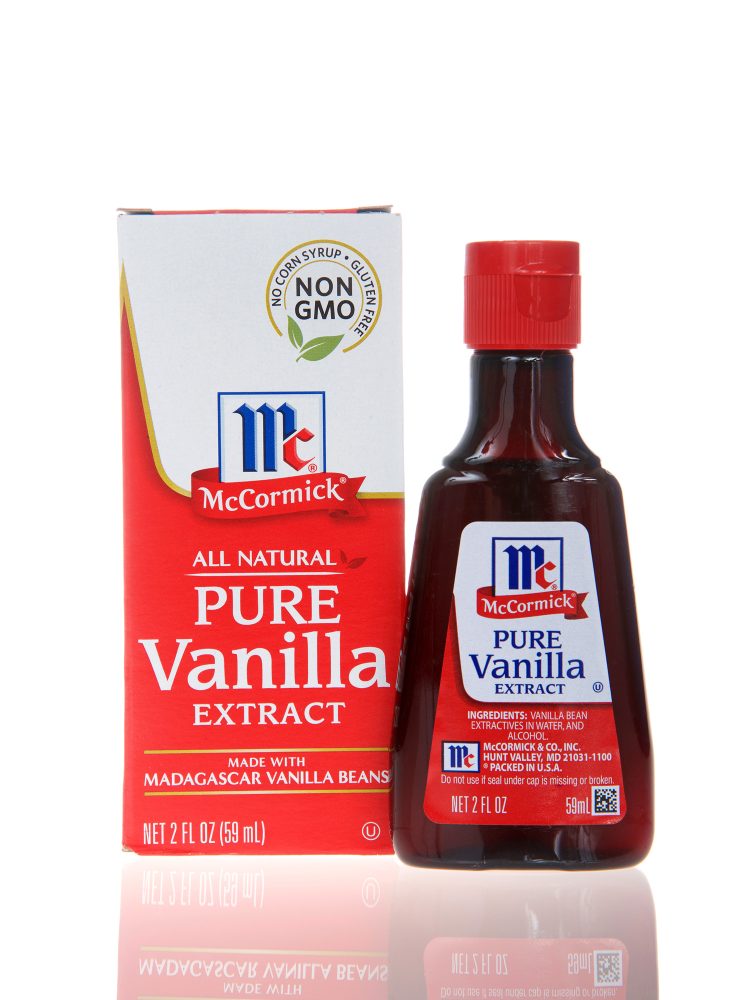 One 2 fluid ounce bottle of McCormick brand pure vanilla extract on a white reflective surface.