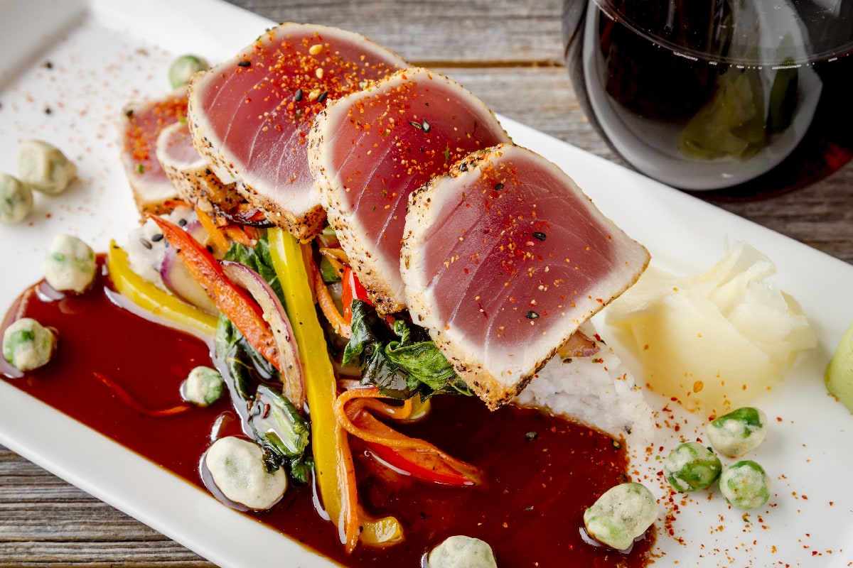 Plate of rare seared Ahi tuna slices with bok choy stir fry vegetables