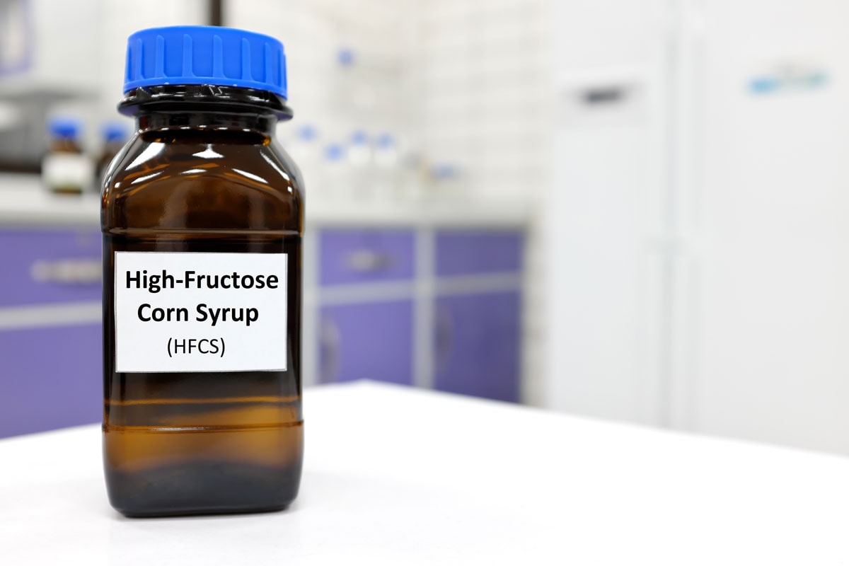 Selective focus of high-fructose high fructose corn syrup or hfcs food and beverage sweetener in dark brown glass bottle inside a laboratory