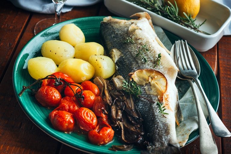 Serve seabass baked with potatoes and tomatoes, What Kind Of Fish Is A Branzino? [& Is It Edible]