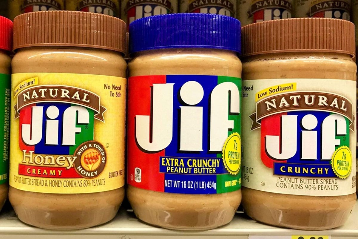 Several Jars of Jif peanut butter on shelve at a grocery store