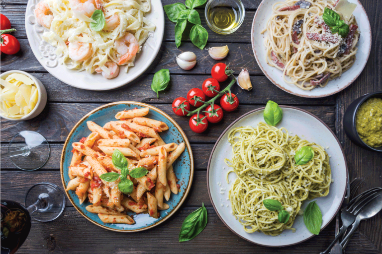 Several plates of pasta with different kinds of sauce over wooden background, top view. Arcopal Vs Luminarc Vs Corelle Which Is Better For Your Kitchen
