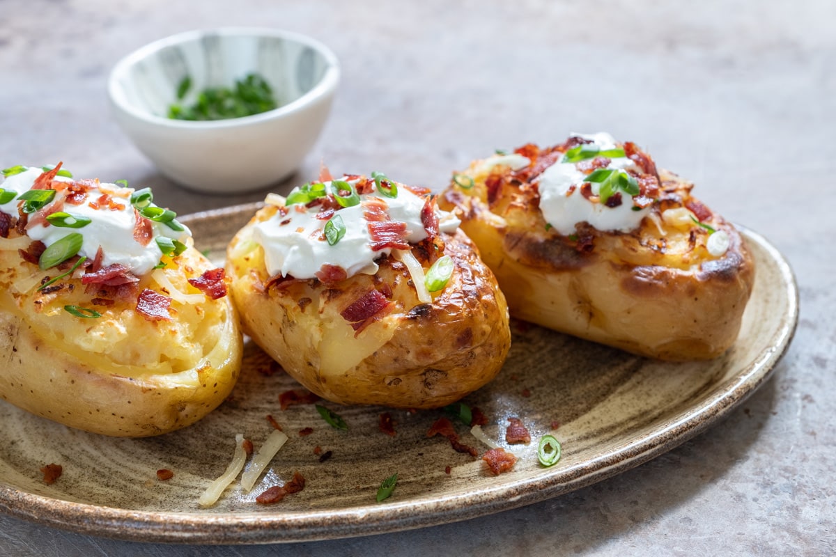 Baked loaded potato with bacon, cheese, sour cream and onion