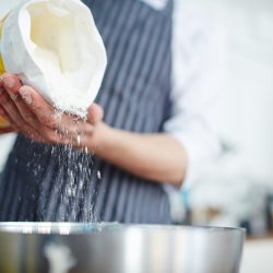 Baker adding flour in bowl to make dough, Bakers Flour Vs Bread Flour: Uses & Differences