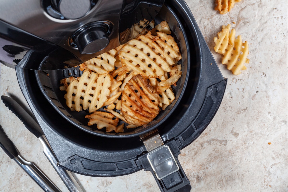 Close up flat lay image of an air fryer oven on kitchen countertop. 