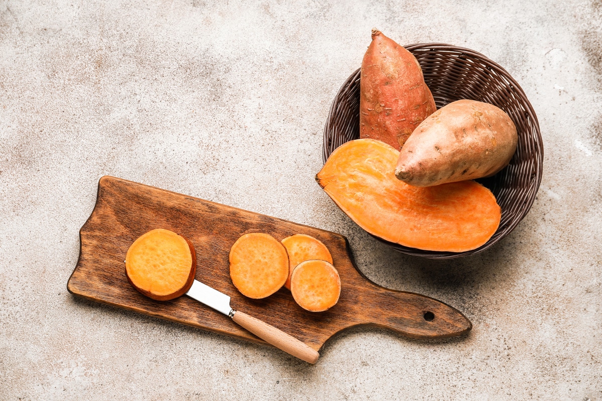 Composition with fresh sweet potato on light background