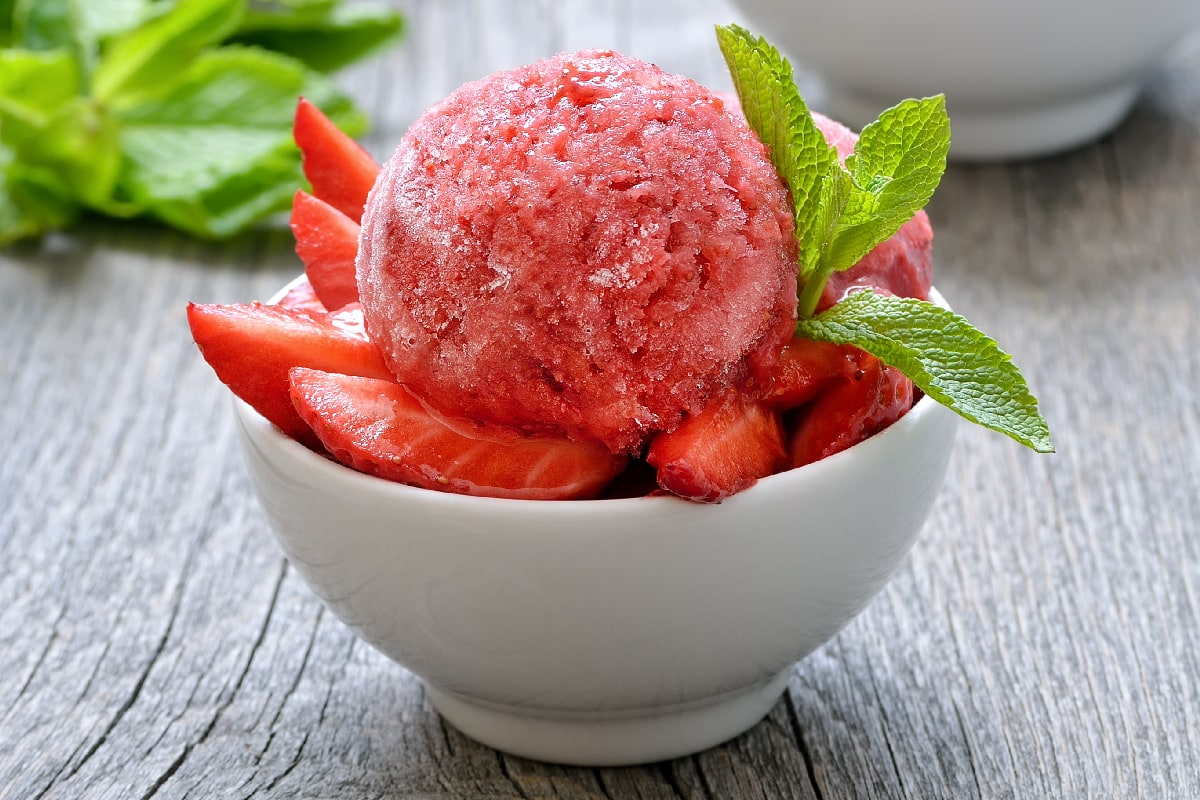 Fruit strawberry sorbet with mint in a bowl on wooden table