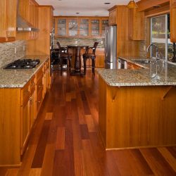 Gorgeous oak cabinets and hardwood flooring of a Galley kitchen with marble countertop, Which Way To Lay Tile In A Galley Kitchen? [With Pictures To Inspire You!]