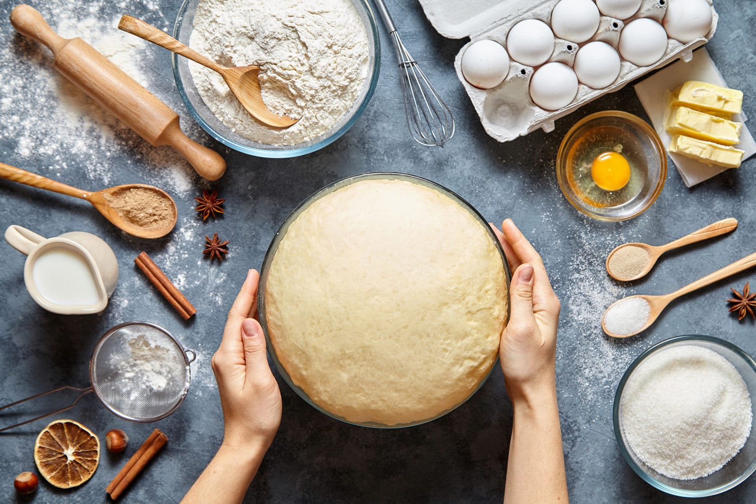 Hands working with dough preparation recipe bread, pizza or pie making ingridients, food flat lay on kitchen table background. Butter, milk, yeast, flour, eggs, sugar pastry or bakery cooking. 