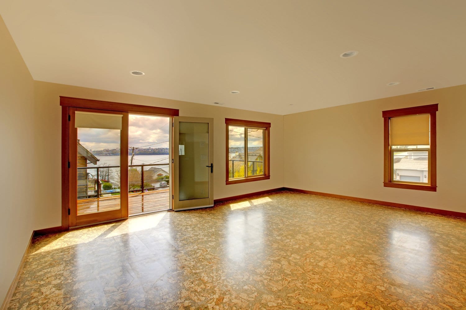 Large bright empty room with cork floor and balcony.New luxury home interior.