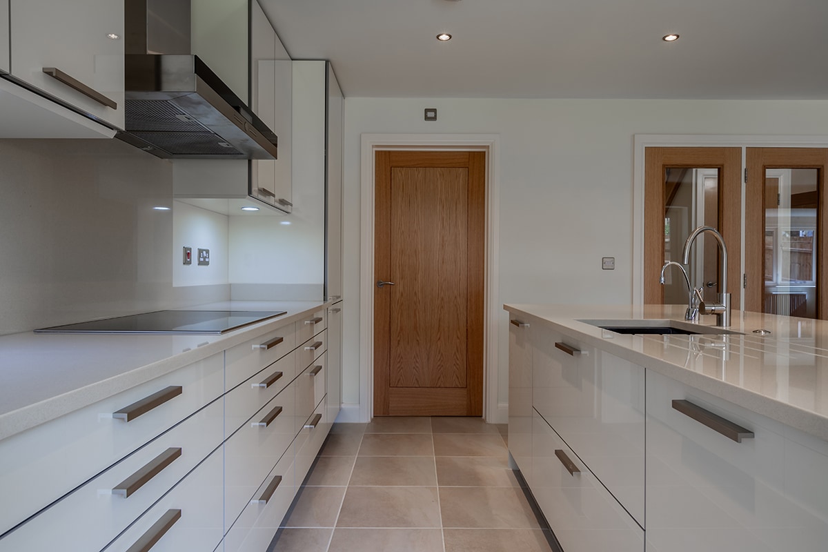 Modern kitchen design galley including fitted cupboards, numerous drawers and built in appliances