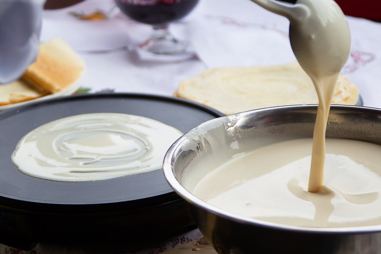 Pour batter for pancakes into a frying pan.