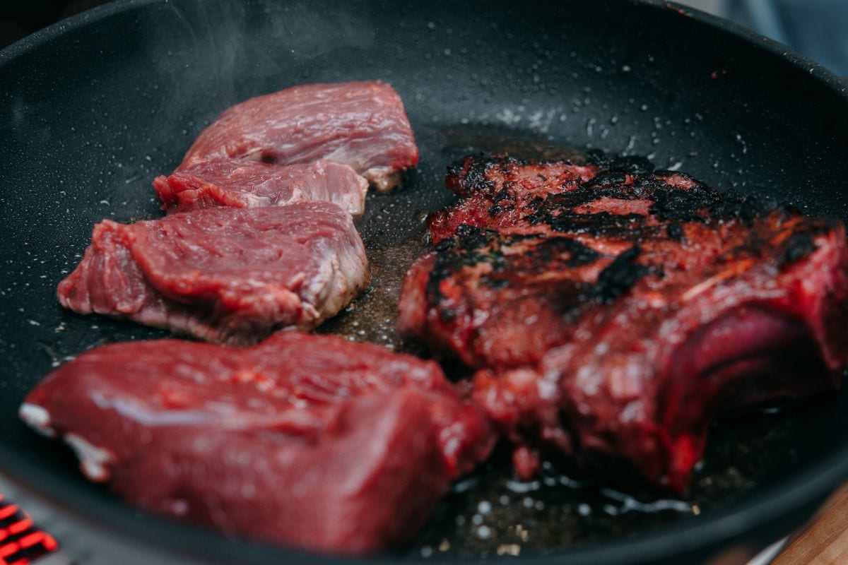 Raw beef meat for cooking steak. Cooking rib eye steak in a frying pan at a cooking class. Burnt steak. Cooking at home, home-made food.