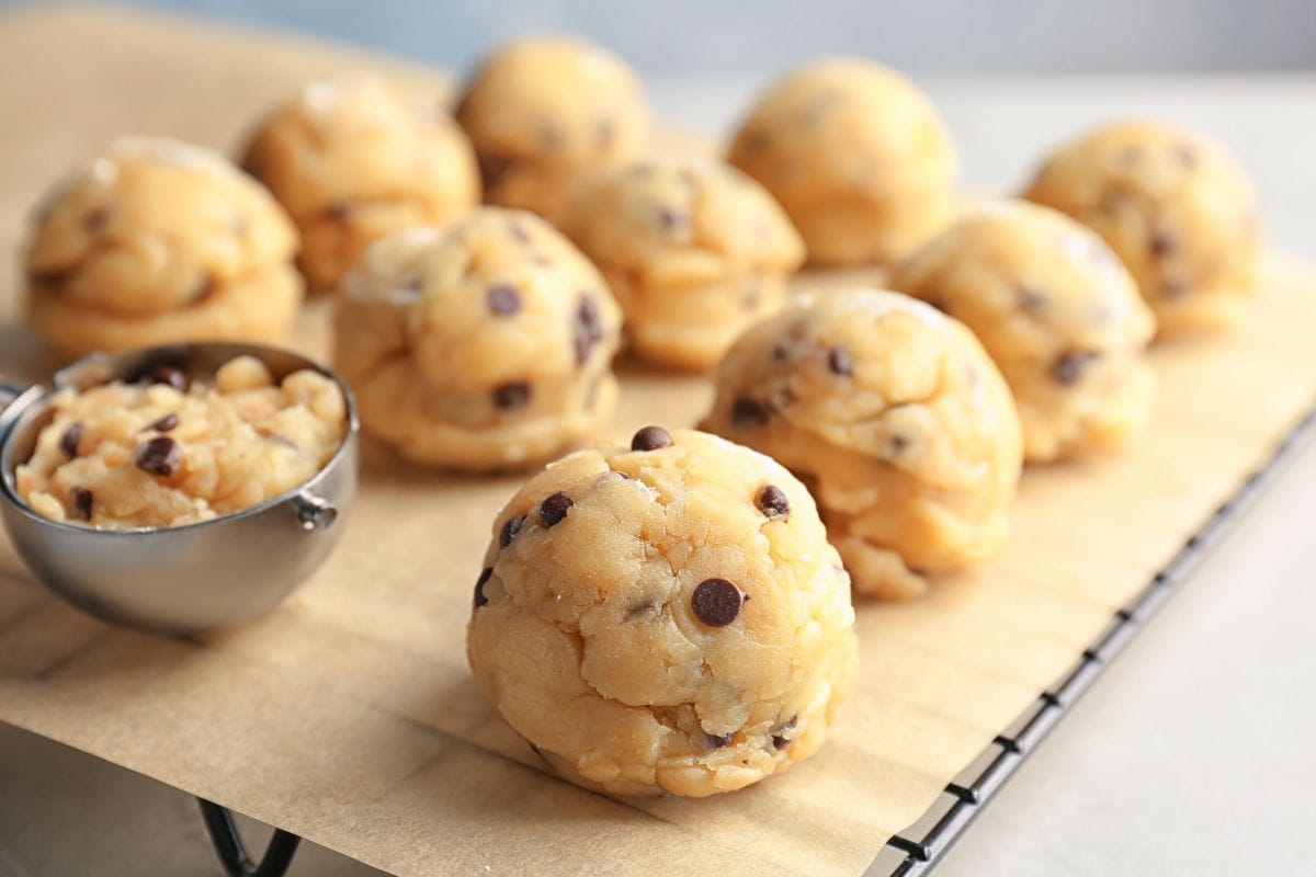 Raw cookie dough with chocolate chips and scoop on parchment paper, closeup. - Raw cookie dough with chocolate chips and scoop on parchment paper, closeup, What Size Cookie Scoop For 1-Inch Balls?