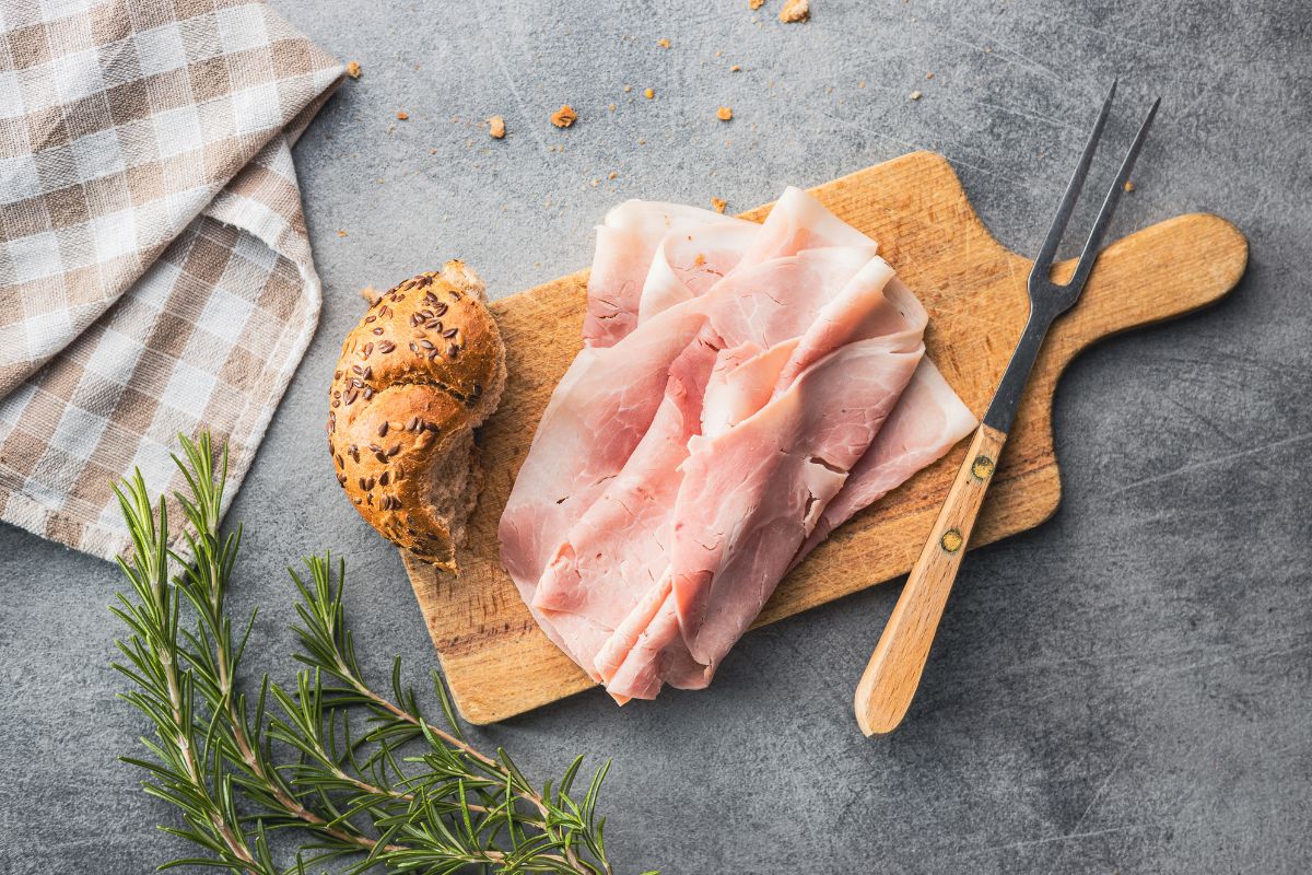 Sliced pork ham on cutting board. Top view.