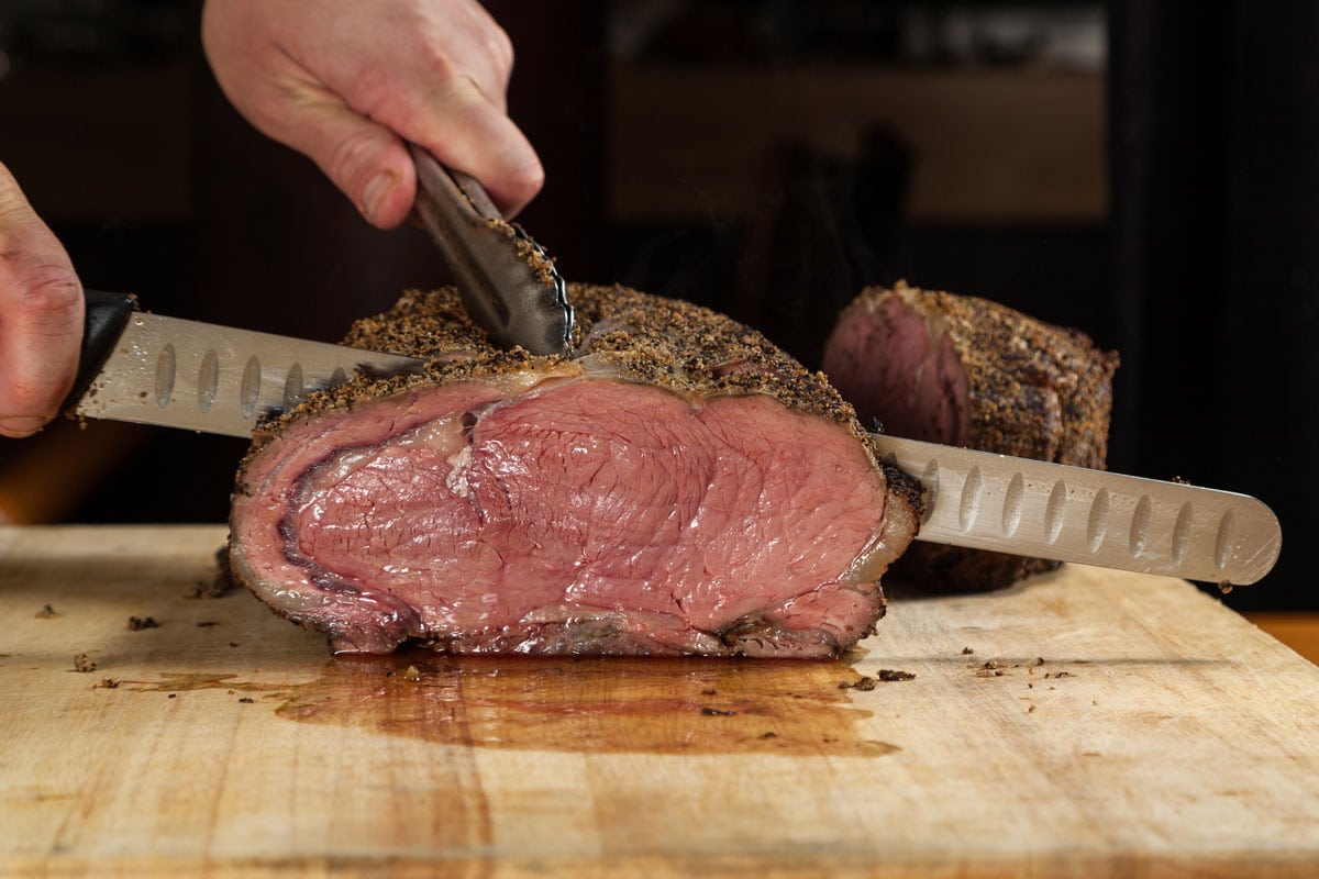 a large Prime rib roast being sliced for dinner service