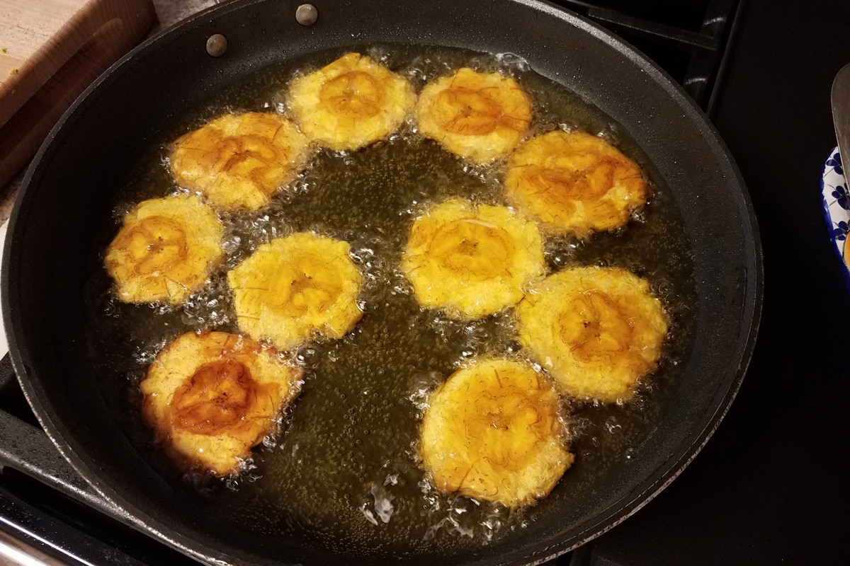 fried plantains in a frying pan with oil Puerto Rico food