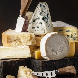 Assortment of different cheese types on a wooden table, Do Goat Cheese and Parmesan Go Together?