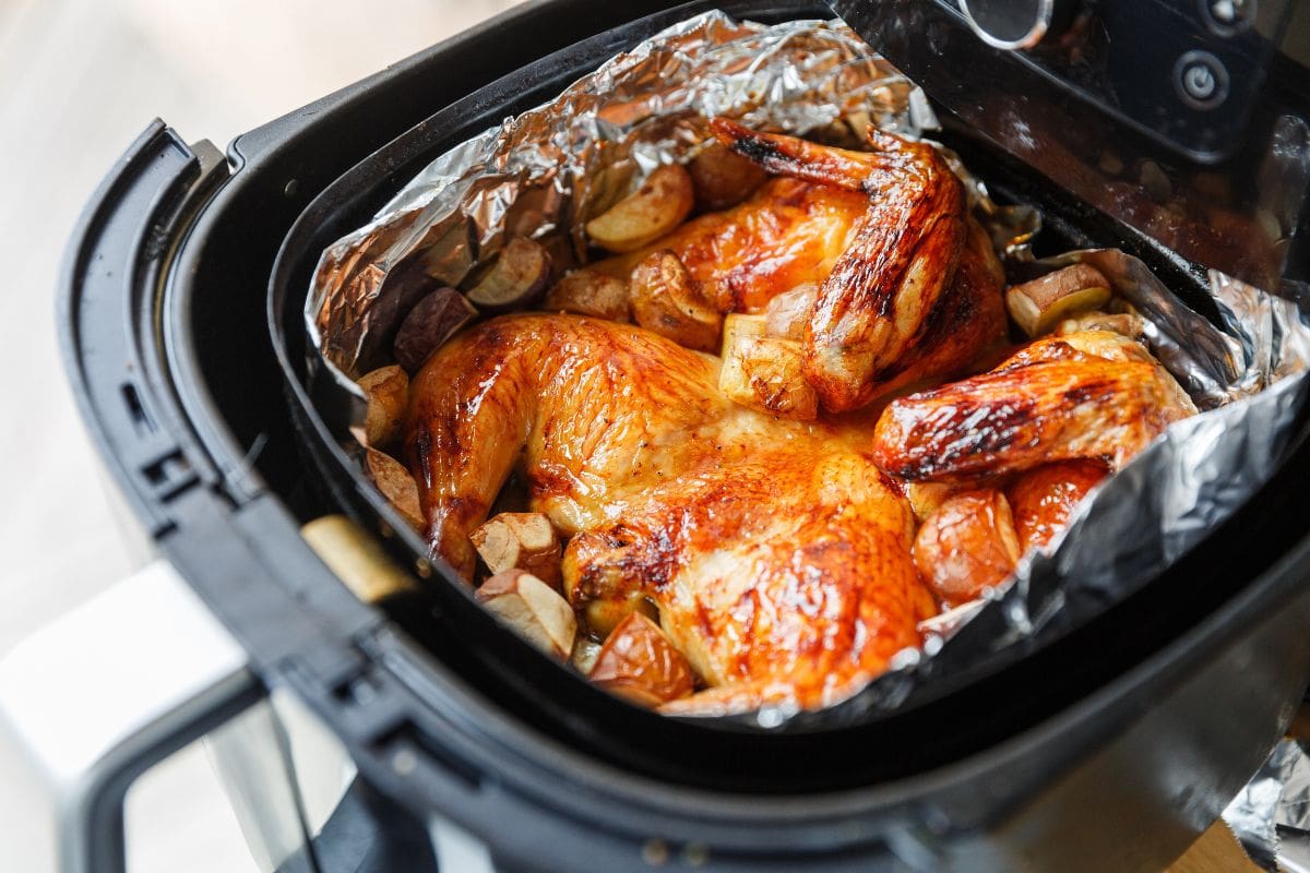 Crispy honey and lemon roasted chicken with potatoes in an air fryer under natural light