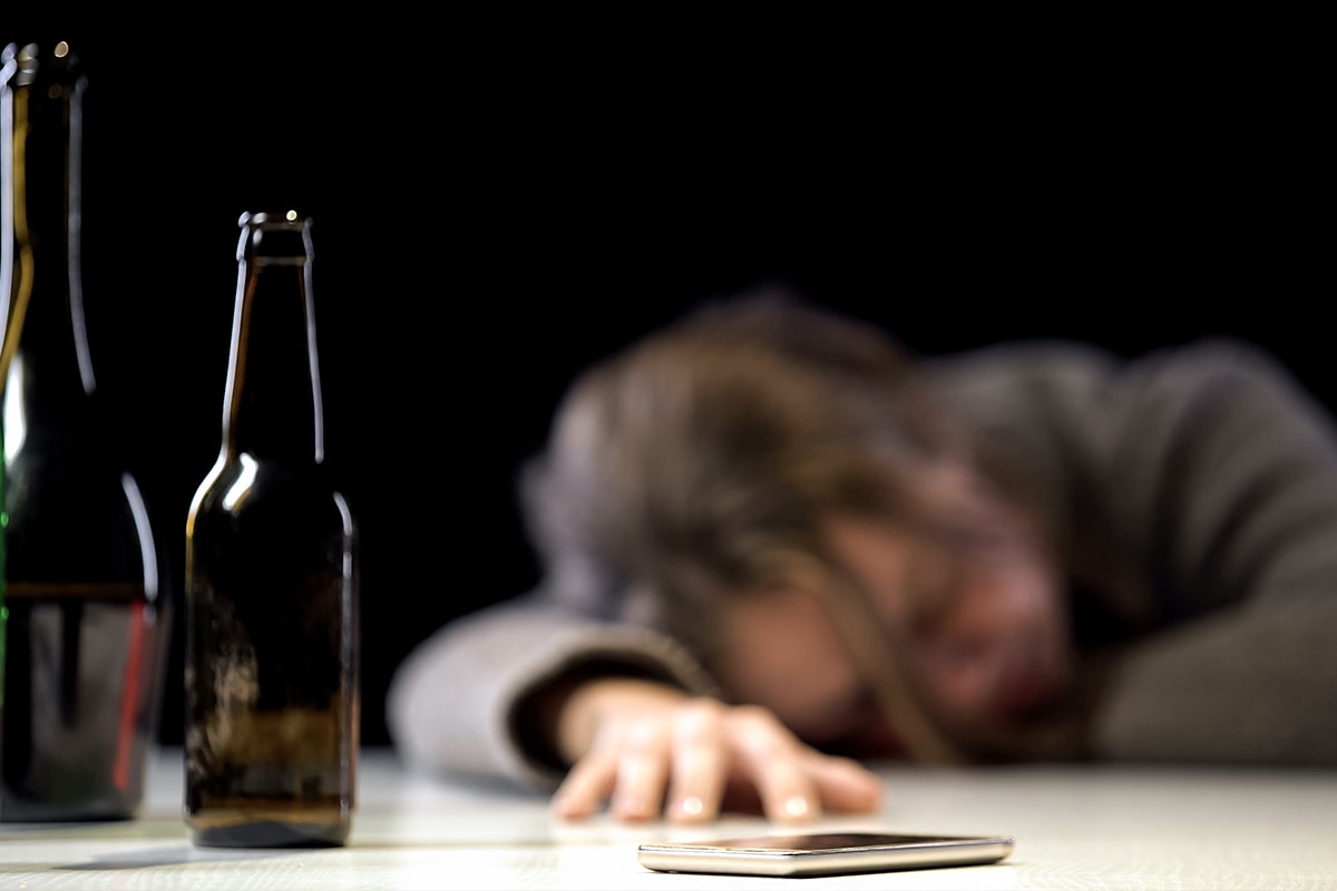 Female suffering alcohol poisoning sleeping on the table