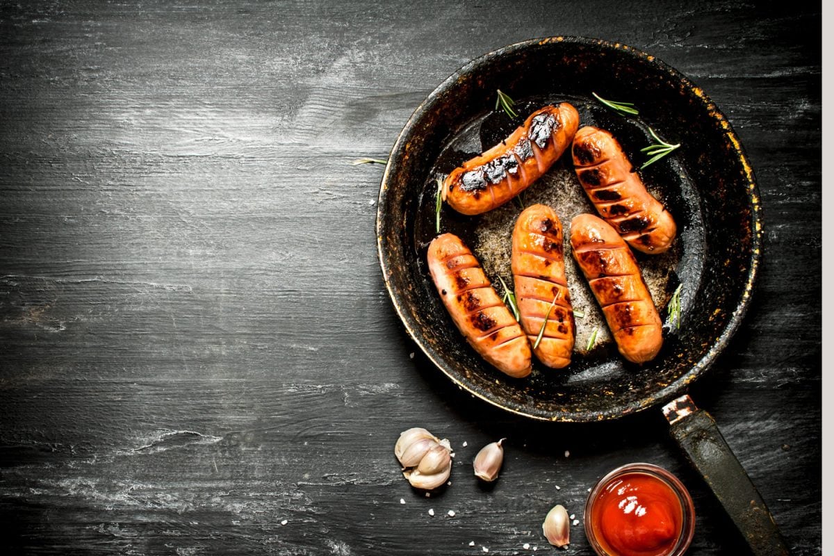 Fried sausages with garlic and tomato sauce in the pan. On the black Board, Do You Have To Cook Smoked Turkey Sausage