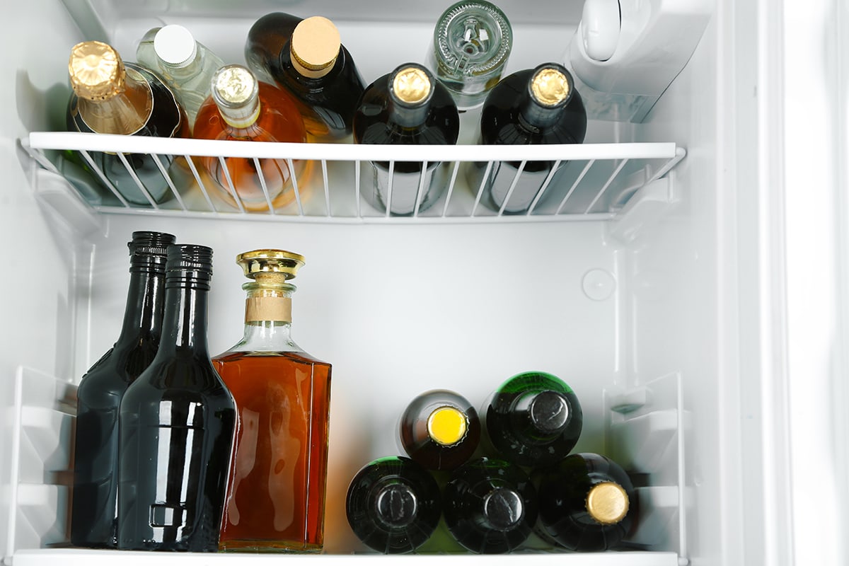 Refrigerator full of bottles with alcoholic drinks