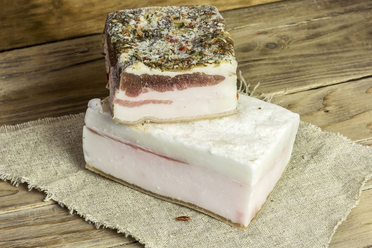 Rustic salted lard lies on a napkin on a wooden surface 