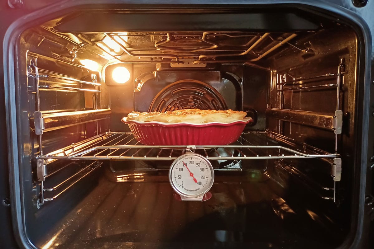The cake is cooked in the oven, the thermometer shows the temperature