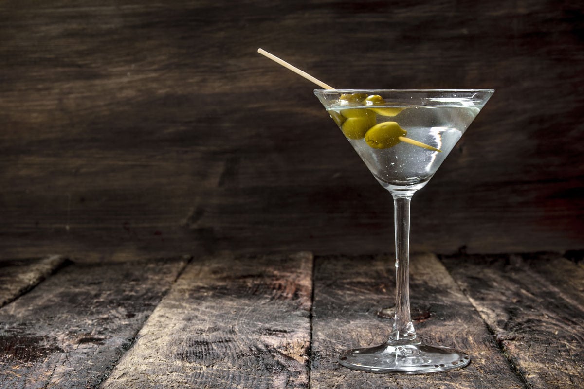 martini olives on wooden background counter top