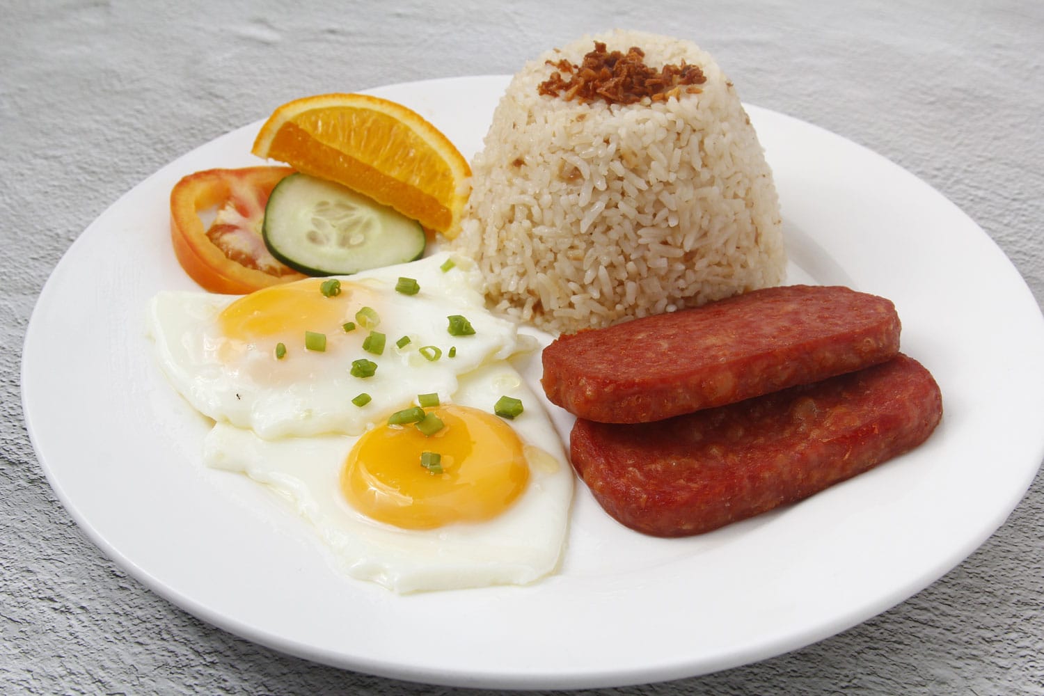 Photo of freshly cooked Filipino food called Spamsilog or slices of spam, egg and fried rice. 
