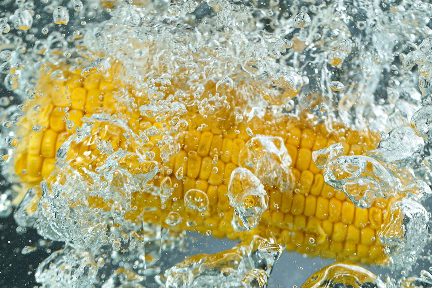 Throwing corn into boiled water, freeze motion, close-up. 