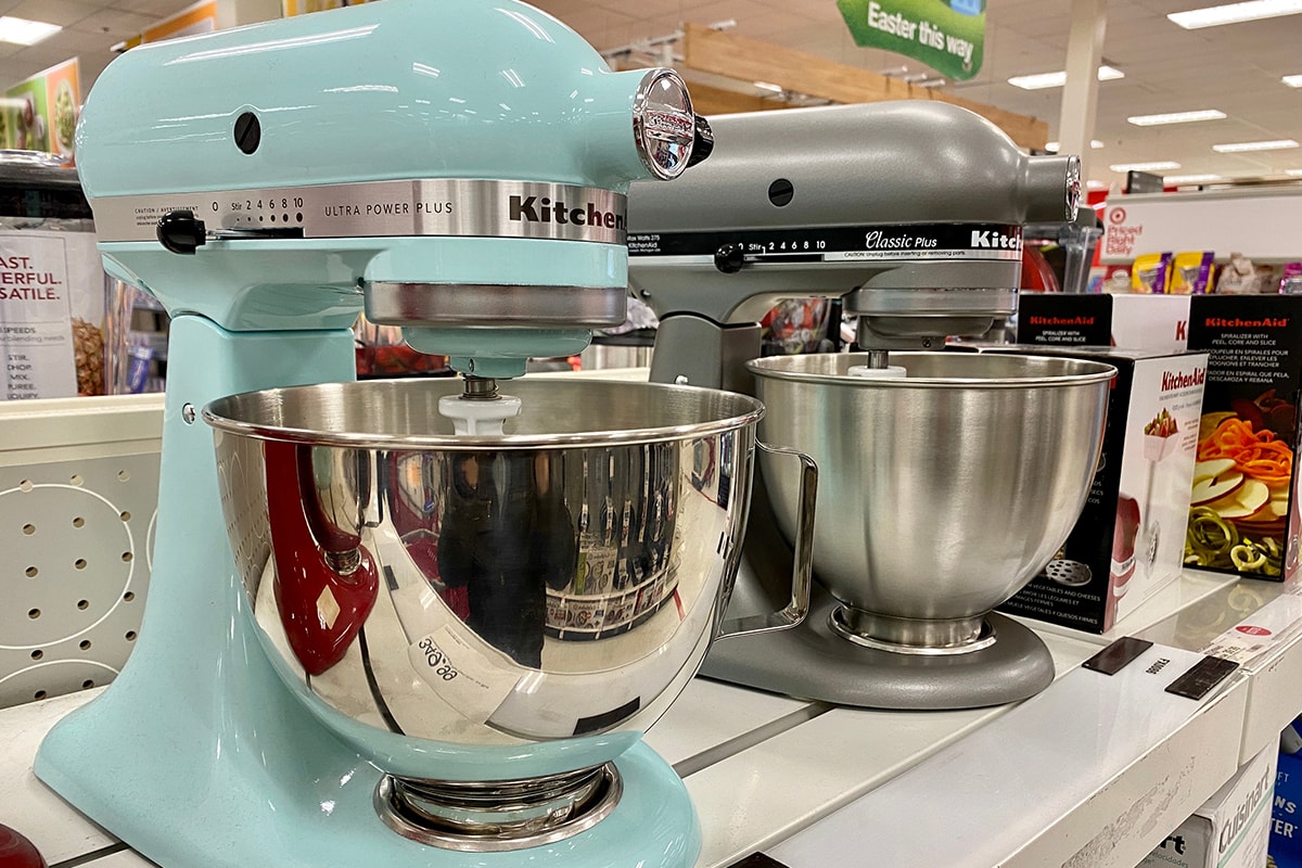 Two models of KitchenAid food mixers on a store shelf inside Target
