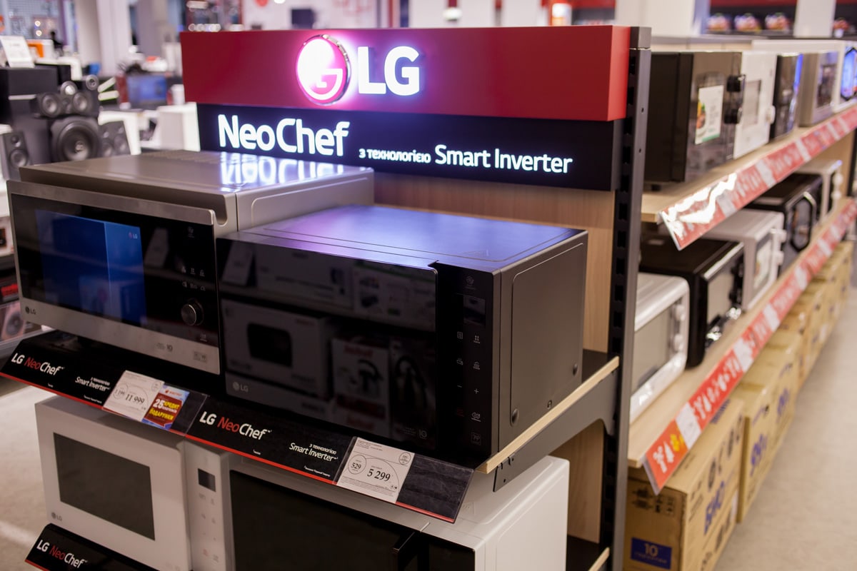 LG microwave ovens stand on a stand in a retail store