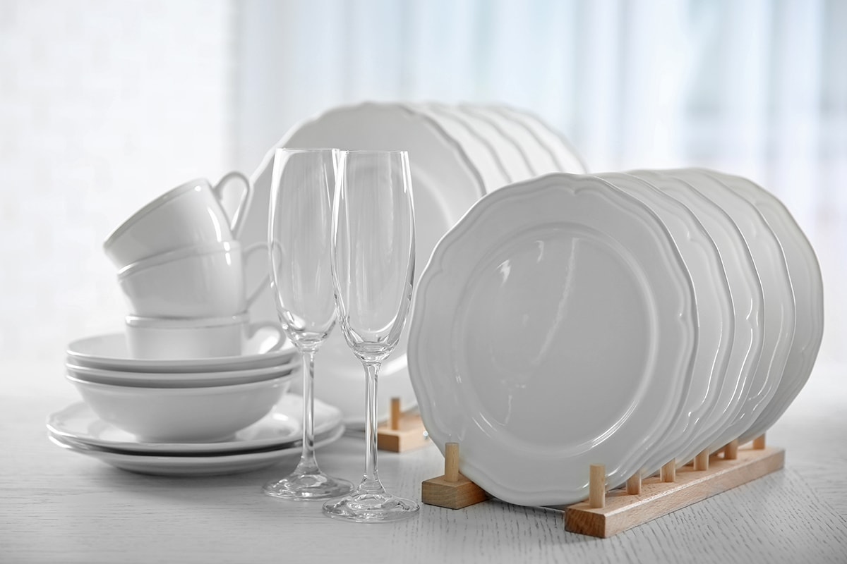 Set of new white dishes on wooden table