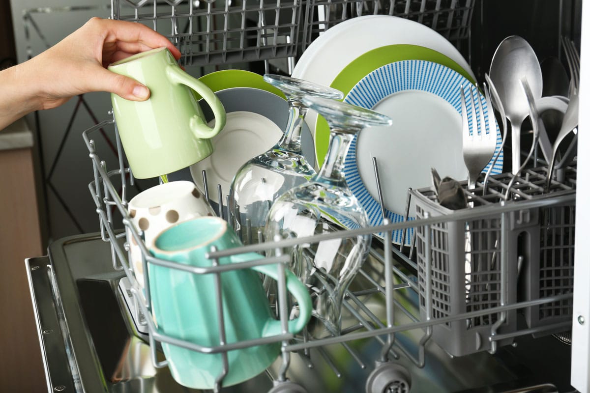 Open dishwasher with clean utensils in it 