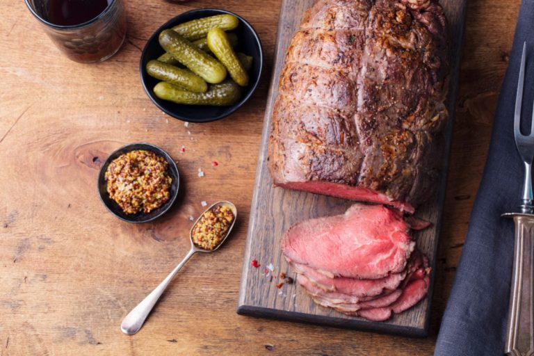 Roast beef on cutting board. Wooden background. - Why Is My Roast Not Falling Apart? [4 Tips For Your Success!]