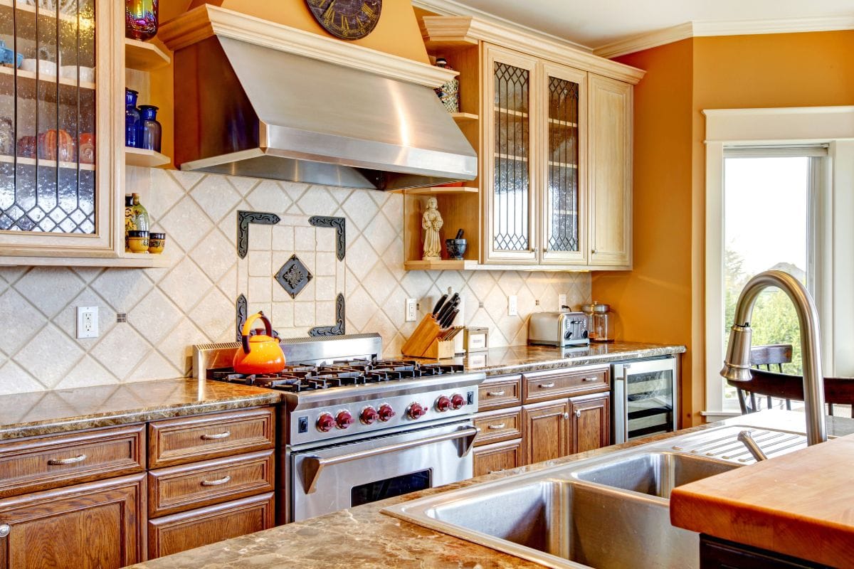 Yellow tones kitchen with tile decorated back-plash, kitchen appliances