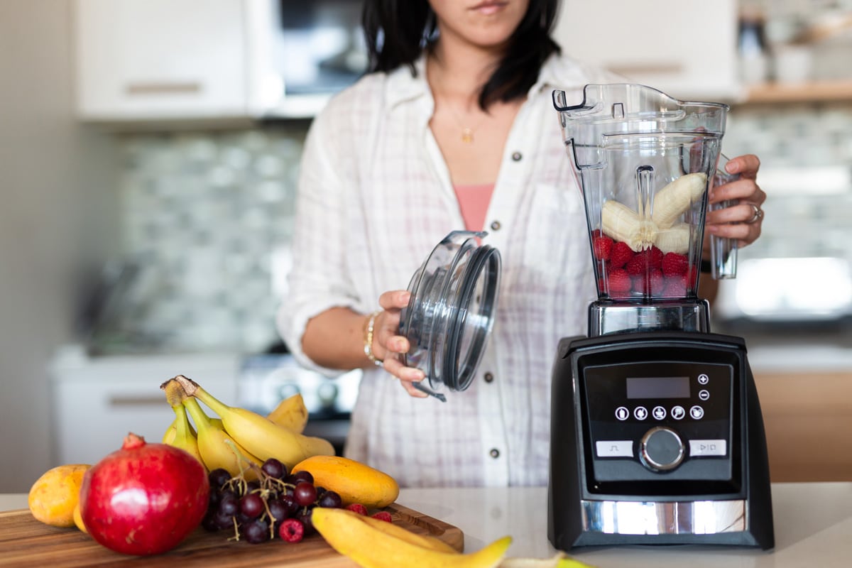Woman making a delicious fruit shake using a Vitamix blender, Where Is The Vitamix Reset Button? A Quick Guide For Troubleshooting