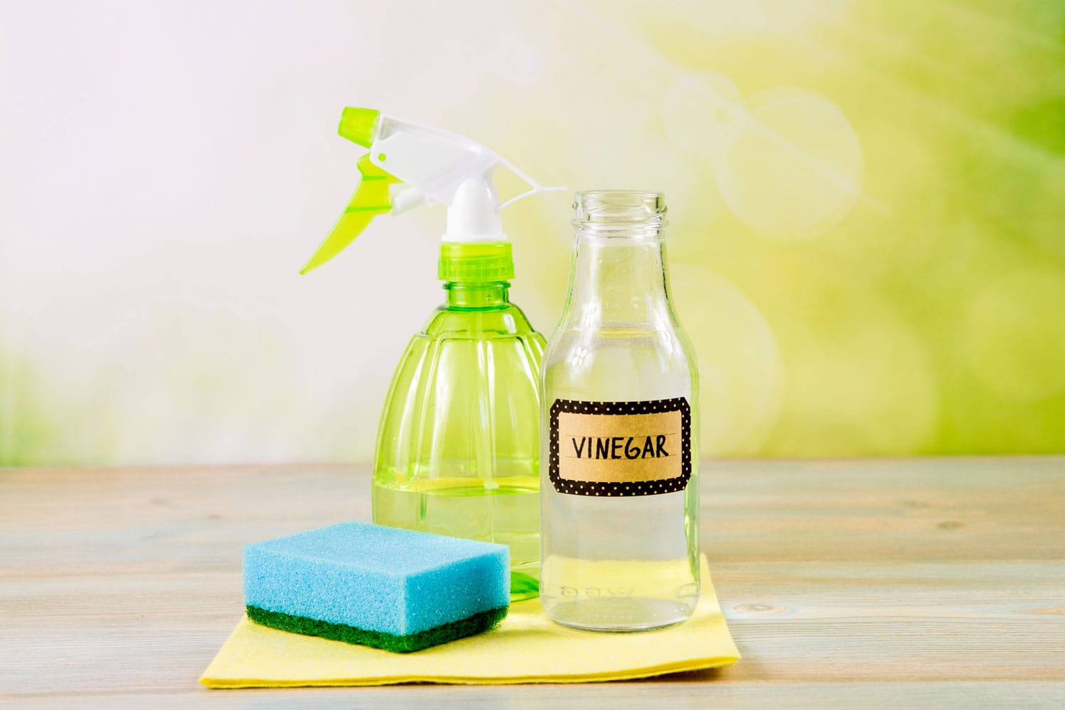 Chemical free home cleaner products concept. Using natural destilled white vinegar in spray bottle to remove stains.