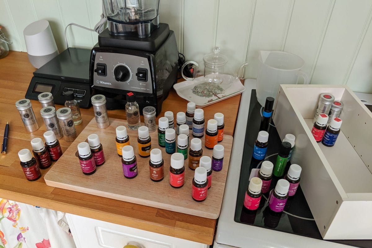 A huge collection of essential oils and a Vitamix blender on the back