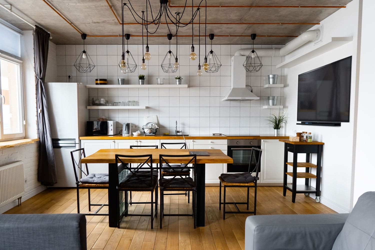 Industrial themed modern kitchen with wooden flooring 