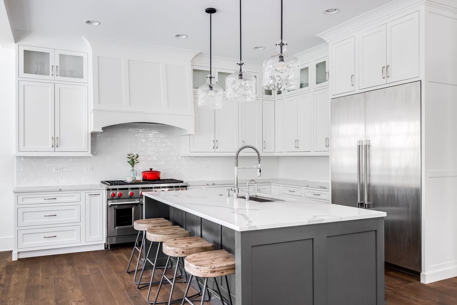 A large luxury kitchen with white granite countertops and cabinets
