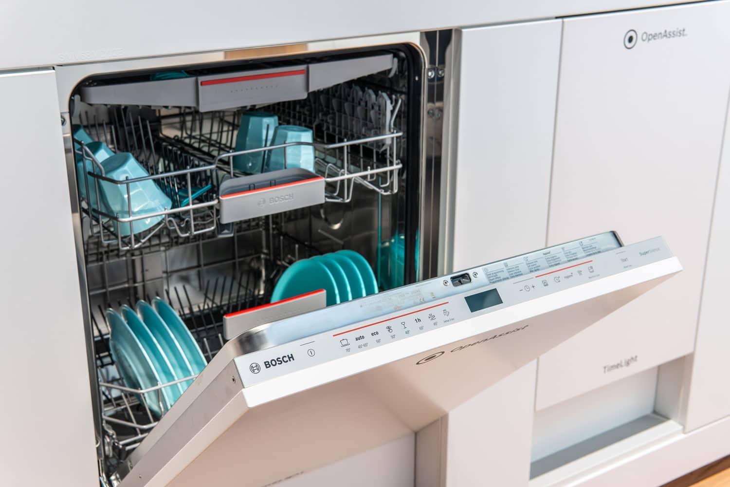 An opened Bosch dishwasher inside a modern kitchen 