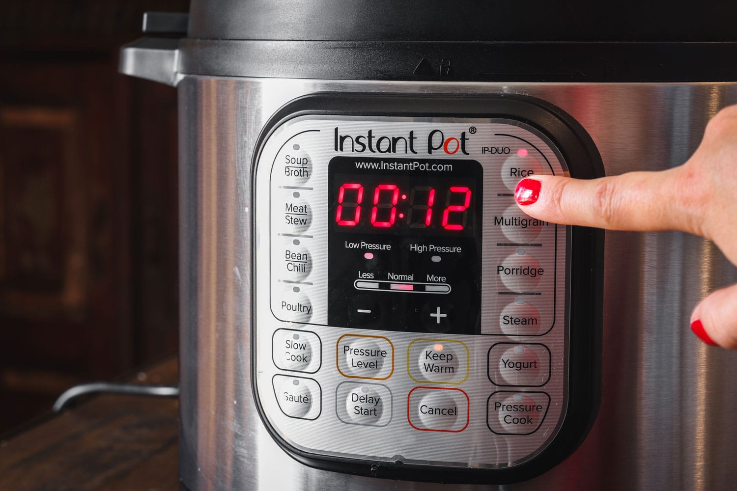 A cook changing the settings of an instant pot